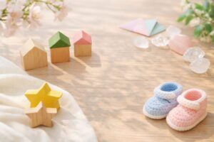 やわらかな光の中で、木製の家型オブジェや星、ベビーシューズが並ぶ、赤ちゃんの名付けをやさしくイメージさせる写真（地格38画）